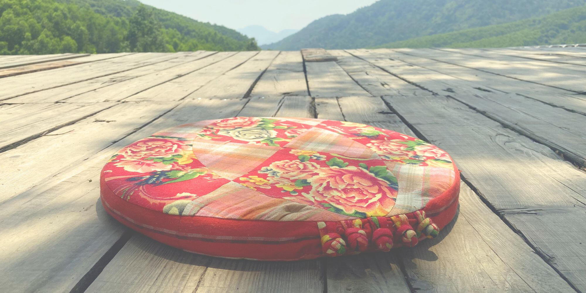 Circular textile cushion installed on a wooden platform overlooking a valley in Đà Nẵng.