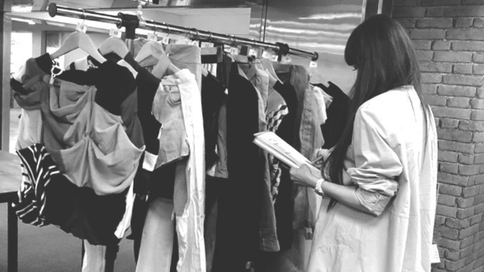 Design juror reviewing reconstructed uniform garments.