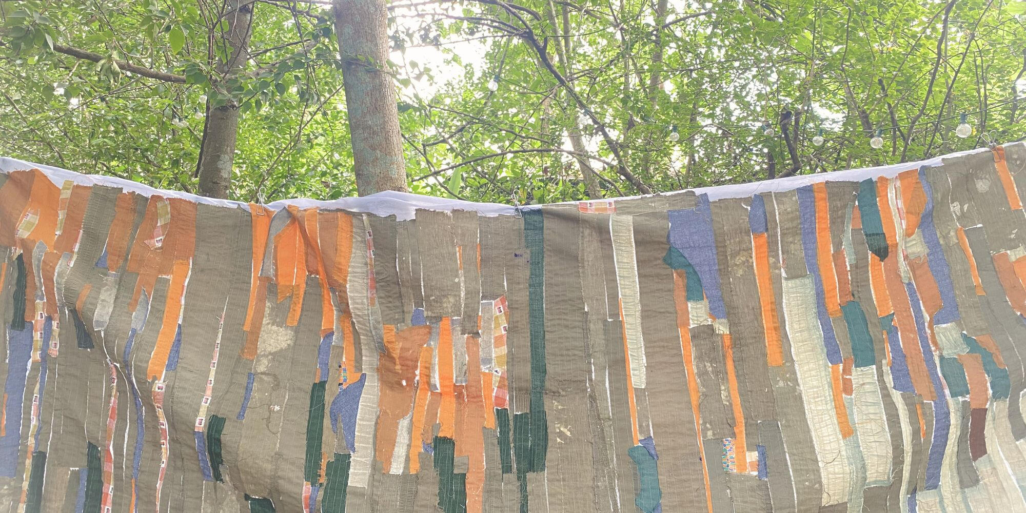Suspended textile installation hanging among trees in Đà Nẵng.