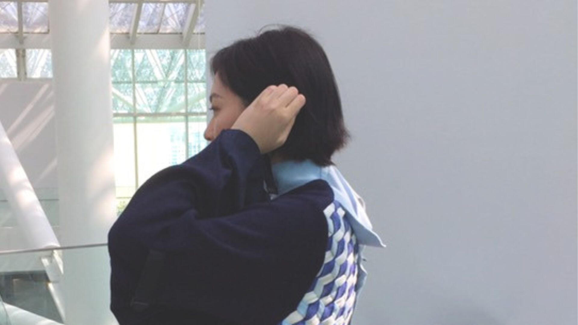 Person wearing a reconstructed uniform garment viewed from the side.